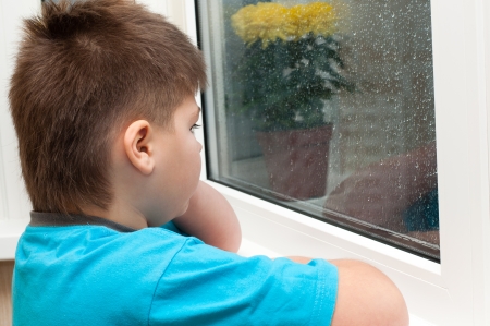 A boy looks out the windowの写真素材