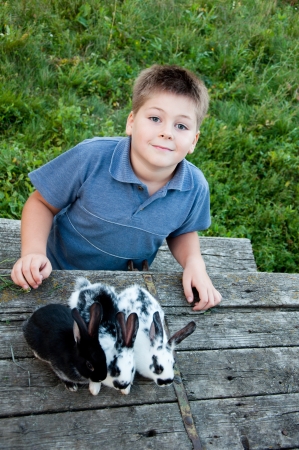 A boy with a rabbit in the gardenの写真素材