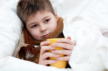 Sick boy lying in bedの写真素材