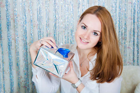 A young woman with gifts near a Christmas treeの写真素材