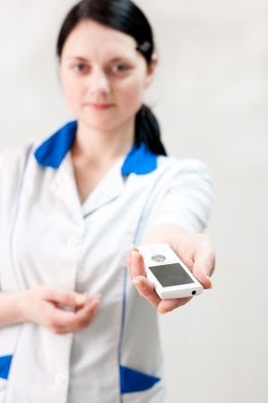 Woman doctor hands mobile phoneの写真素材