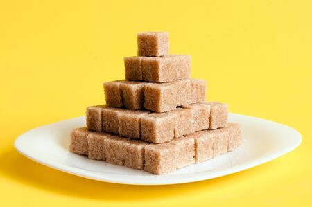 Unrefined sugar on a yellow backgroundの写真素材