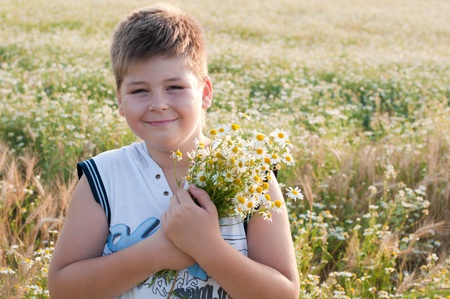A boy with a bouquet of daisies in a fieldの写真素材