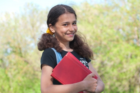 Teen girl with books on natureの写真素材