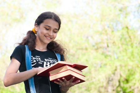 Teen girl with books on natureの写真素材