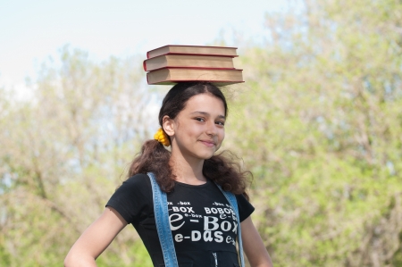 Teen girl with books on natureの写真素材