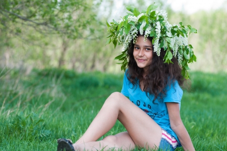Teen girl with a wreath of cherry blossoms on her headの写真素材