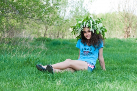 Teen girl with a wreath of cherry blossoms on her headの写真素材