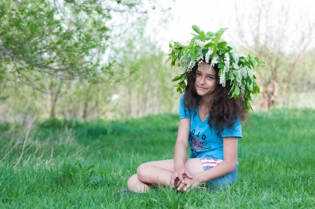 Teen girl with a wreath of cherry blossoms on her headの写真素材
