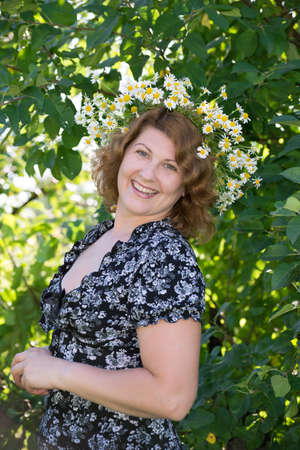 A woman with a wreath of daisies on her headの写真素材