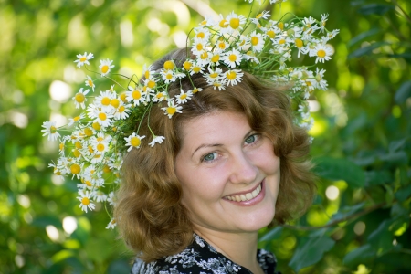 A woman with a wreath of daisies on her headの写真素材