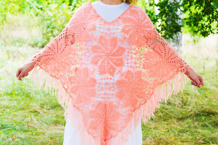 Woman in a knitted poncho in natureの写真素材