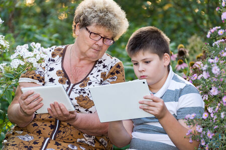 Grandma with a grandson watching tablet PCの写真素材
