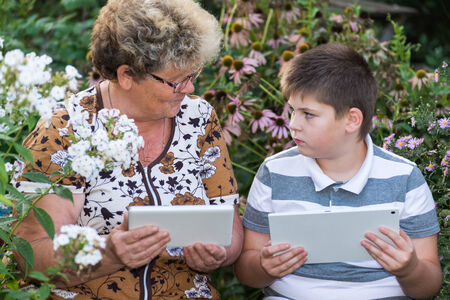 Grandma with a grandson watching tablet PCの写真素材