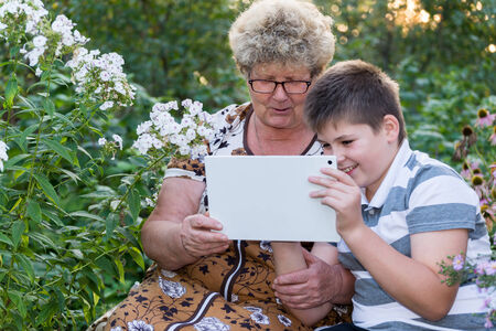 Grandma with a grandson watching tablet PCの写真素材