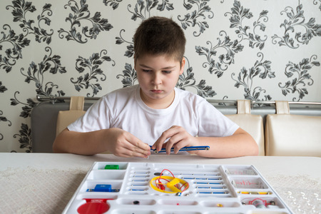 a Teen boy at home with electronic project