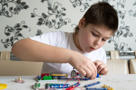 a Teen boy at home with electronic project