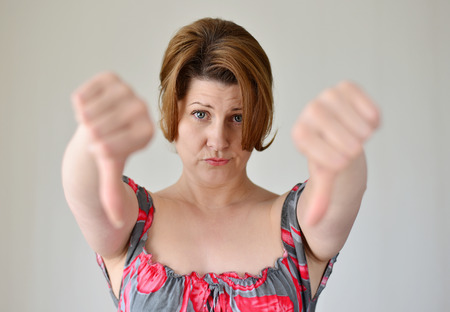 angry young woman showing her thumb downの写真素材