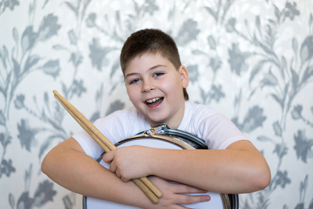 Teenager boy with a drum in the room