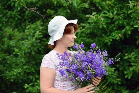 Woman with a bouquet of a wild flowers Outdoorsの写真素材