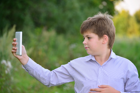 Teen boy with a tablet computer at natureの写真素材