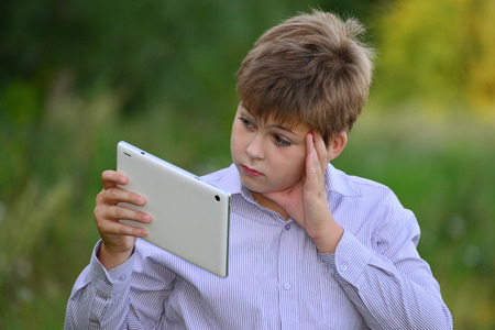 Teen boy with a tablet computer at natureの写真素材