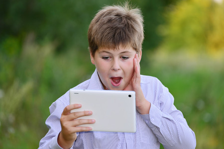 Teen boy with a tablet computer at natureの写真素材