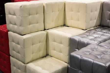 Many leather footstools of different colors in the stackの写真素材