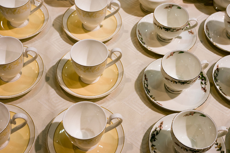 Many tea cups and saucers are on the tableの写真素材