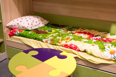 Fragment of interior children's room with a table in the form of a puzzle