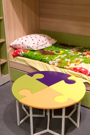 Fragment of interior children's room with a table in the form of a puzzle