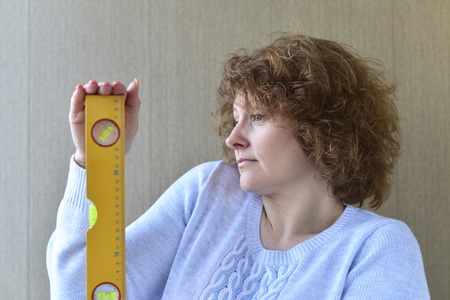 A woman is holding a construction toolsの写真素材