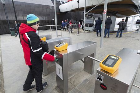 Nizhny Novgorod, RUSSIA - November 04.2015. The boy goes through the turnstile cable car. It across the river Volga is the longest in the countryのeditorial素材