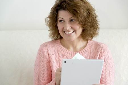 woman with tablet pc computer and credit card and money at homeの写真素材