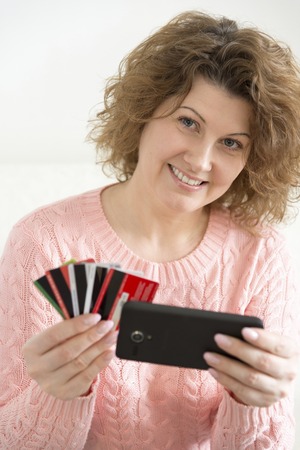 An adult woman makes a purchase from your mobile phone by credit card