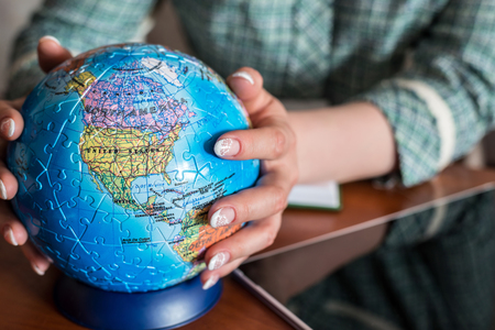 Seated at the table woman holding a globe