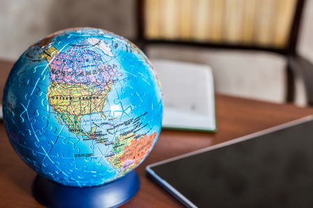 A Globe, tablet and diary on the tableの写真素材