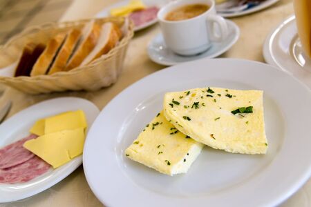 Breakfast with omelet and coffee on the table in a cafeの写真素材