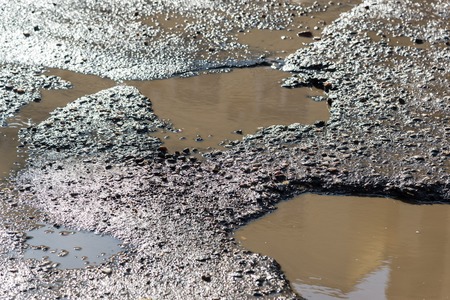 Potholes on the asphalt road filled with water