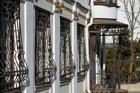 Metal wrought-iron bars on the windows of an apartment houseの写真素材