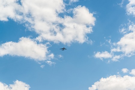 Blue sky with clouds on summer day with a small planeの写真素材
