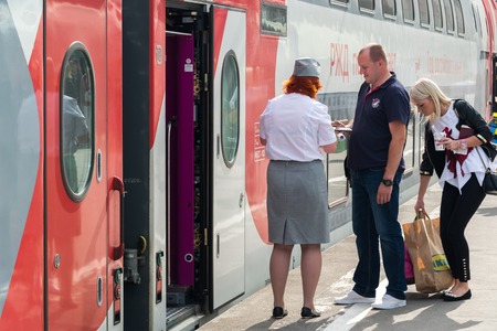 Moscow, Russia - June 14.2016. The conductor checks the tickets and documents when boarding the trainのeditorial素材