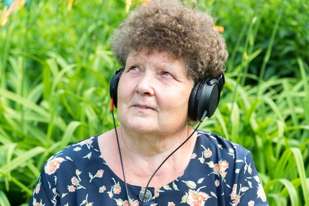 Curly woman listening to music through headphonesの写真素材