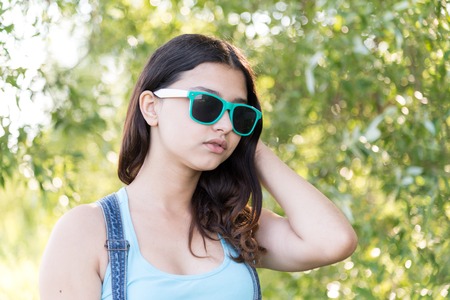 Portrait of teen girl in sunglasses on a nature summerの写真素材