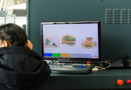 An X-ray monitor at airport and woman from security service.の写真素材