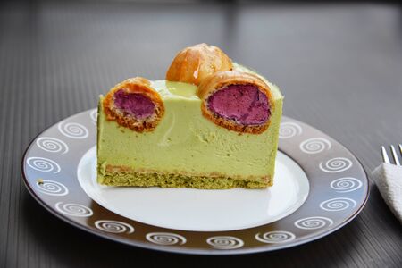 Piece of pistachio cake with a profitroles