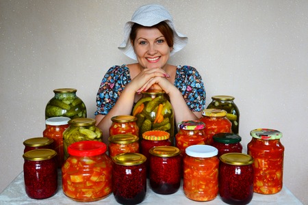Happy housewife with homemade canned foodの写真素材
