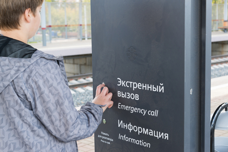 Teenager presses the emergency call button at stationの写真素材