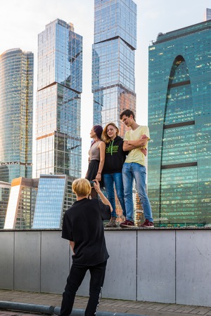 Moscow, Russia - November 2. 2017. Teenagers are photographed in background of a skyscrapers of Moscow Cityのeditorial素材