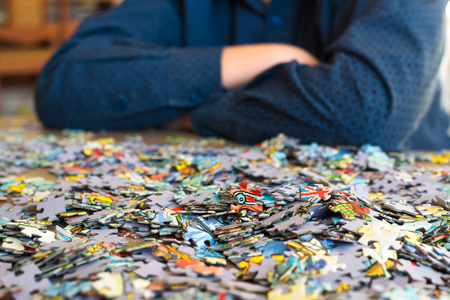 A teenager collects puzzles on a coffee table.の写真素材